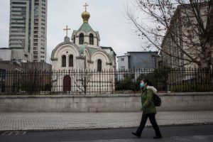 A women wears a protective mask as she past the church on February 8, 2020