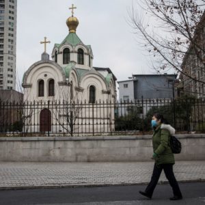 A women wears a protective mask as she past the church on February 8, 2020